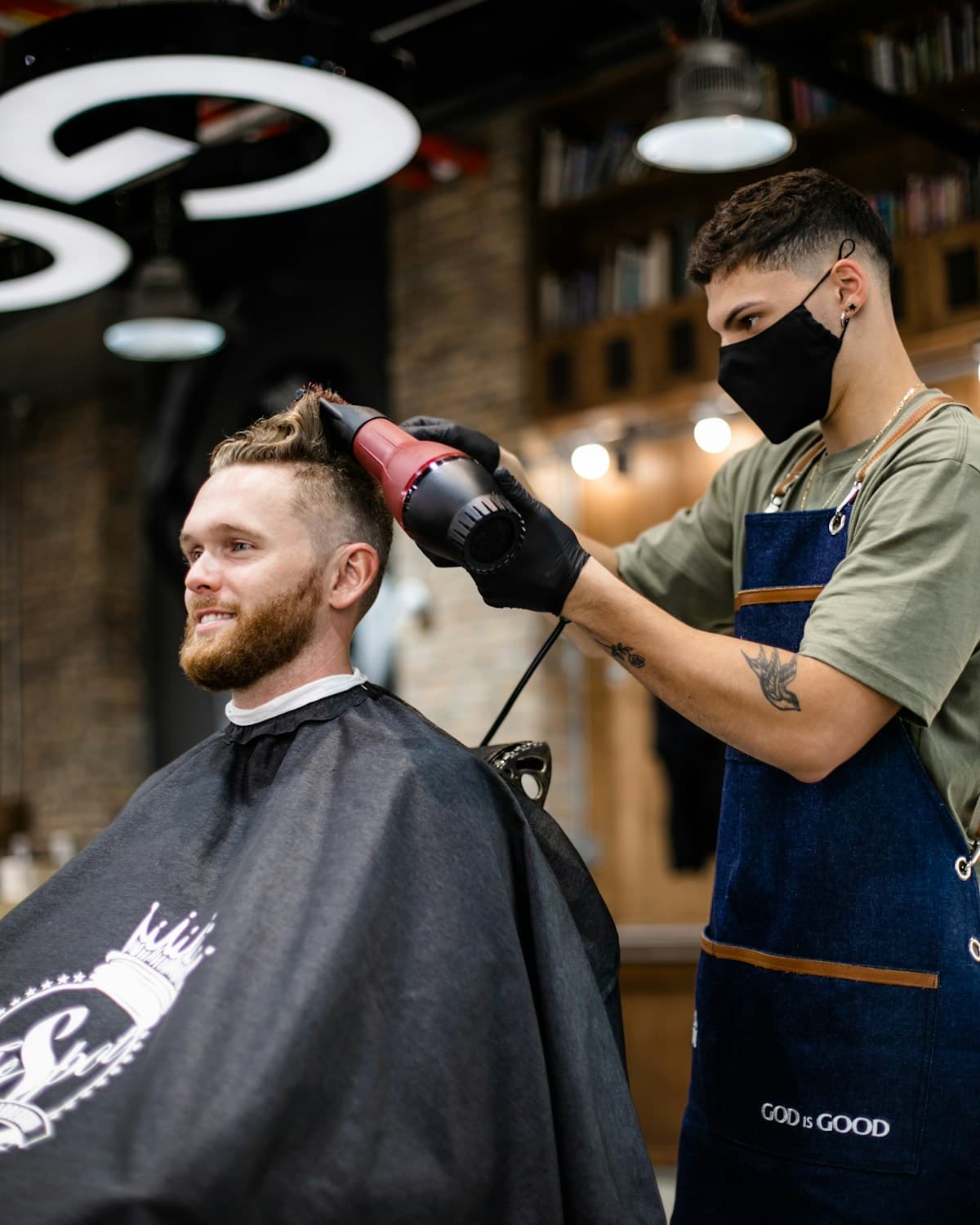 Barber styling a client's hair while tomorrow's appointments confirm themselves
