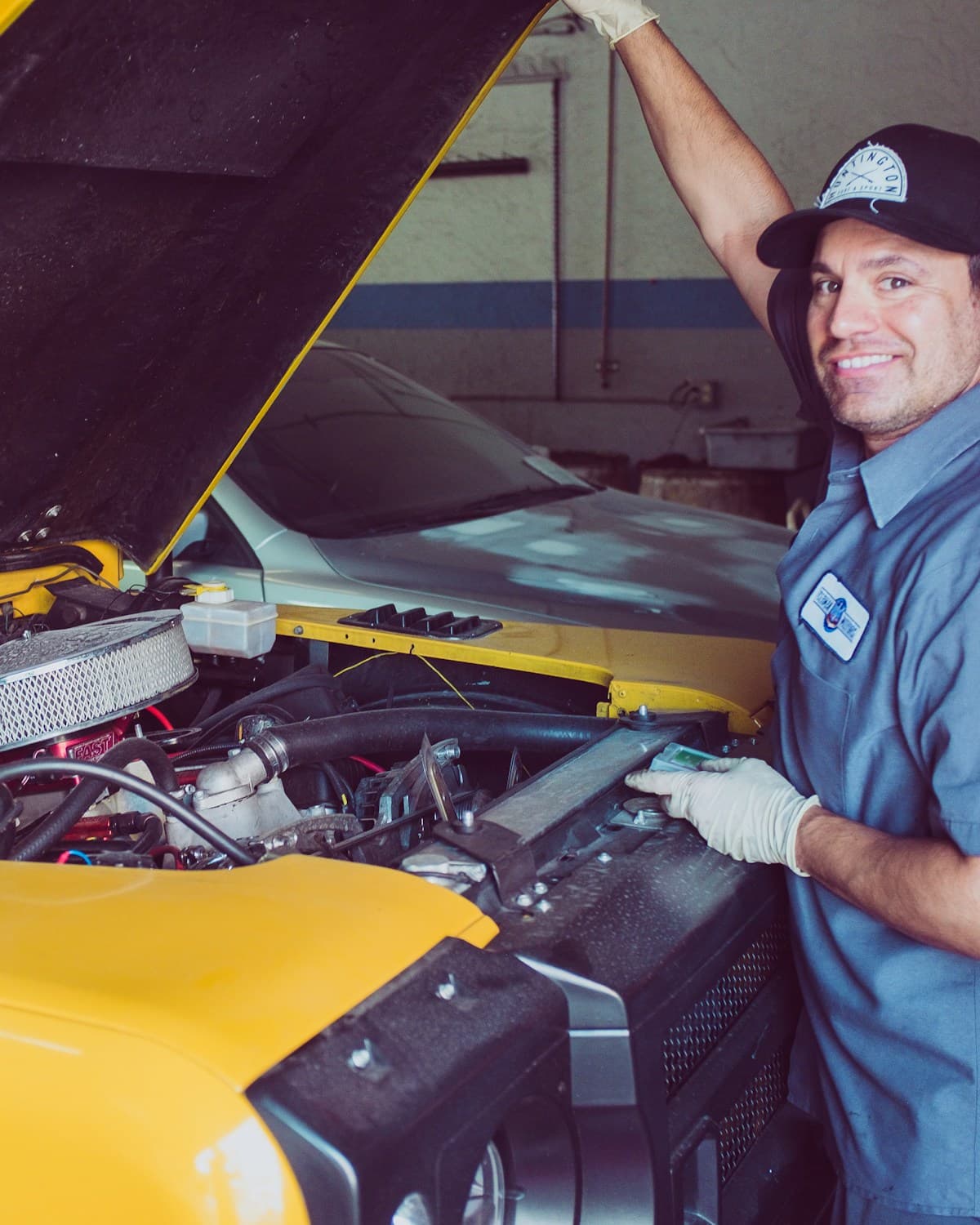 Mechanic under the hood while the repair invoice goes out on its own